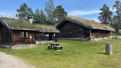 a log building with a grass roof with a picnic table at Cabin With Mountain View Near Lake Totak in Rauland