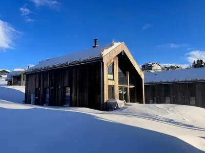 a wooden building with snow on the ground at Modern Cabin With View In Rauland in Rauland