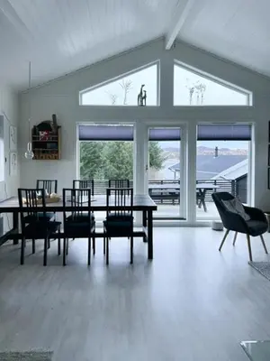 a dining room with a table and chairs and windows at Charming Cabin With Archipelago Views In Sogn in Ånneland