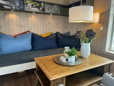 a living room with a blue couch and a table at Family Cabin With Panoramic View Near Vikerfjellet in Hønefoss