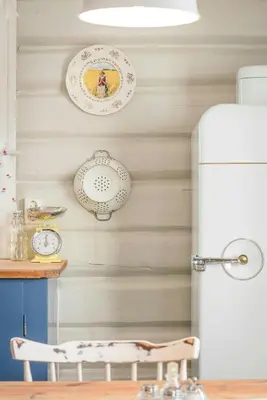 a kitchen with a refrigerator and plates on the wall at Family-Friendly Cabin With Agricultural Idyll in Vestre Gausdal