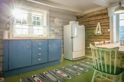 a kitchen with a refrigerator and a table at Family-Friendly Cabin With Agricultural Idyll in Vestre Gausdal