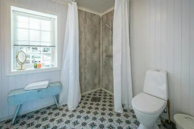 a bathroom with a toilet and a shower and a window at Family-Friendly Cabin With Agricultural Idyll in Vestre Gausdal