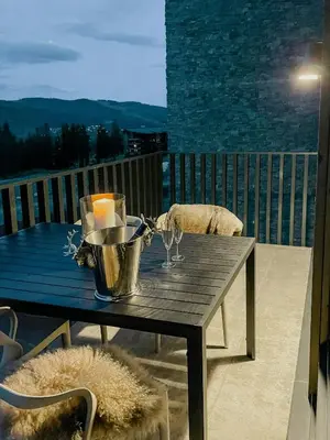 a wooden table with wine glasses on a balcony at Modern Flat In Trysil Alpine Lodge in Trysil