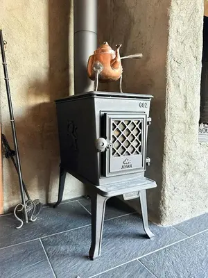 a stove sitting on a stand next to a wall at Peaceful Cabin By Rødungen in Ål