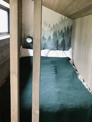 a bed in a room with a painting on the wall at Enjoy Simple Cabin Life In Nature in Kongsberg