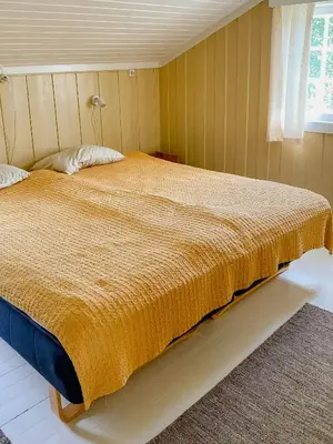 a bedroom with a large bed with a yellow blanket at Fantastic Charming Cabin By Tinnsjøen in Austbygdi