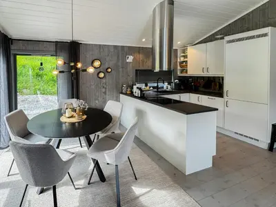 a kitchen with a table and chairs and a counter at Luxury By The Fjord In Ranvik in Eidsvåg