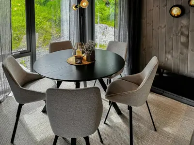 a dining room table with chairs and a glass of wine at Luxury By The Fjord In Ranvik in Eidsvåg