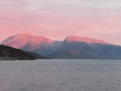 a large body of water with mountains in the background at Charming sea house with sauna and private jetty in Ølve