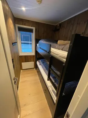 a small room with two bunk beds and a window at Hafjell Alpinlandsby Apartment 43 in Hafjell