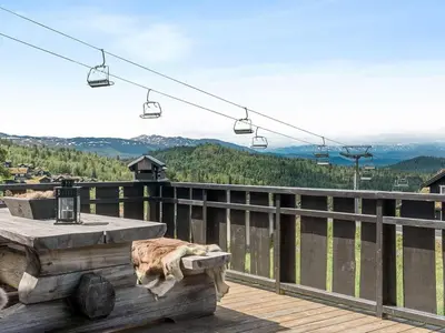 a balcony with a table and chairs and a ski lift at 9 person holiday home in Rauland in Rauland