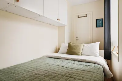 a bedroom with a bed with a green blanket at Unique apartment-Romantic Street-Easy Check-In in Bergen