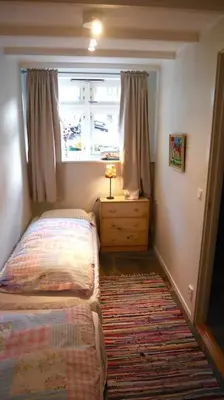 a small bedroom with two beds and a window at In the heart of Bergen in Bergen
