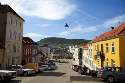 a street in a town with cars parked at In the heart of Bergen in Bergen