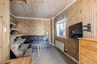 a living room with a blue couch and a table at Moderne hytte plass for 10 in Rendalen