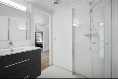 a bathroom with a glass shower and a sink at et fint og stort enebolig sentralt i voss! in Vossevangen