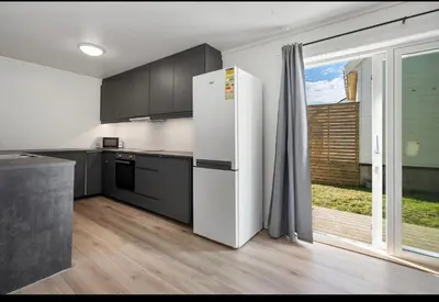 a white refrigerator in a kitchen with a window at et fint og stort enebolig sentralt i voss! in Vossevangen