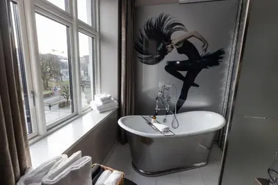 a bathroom with a bird mural on the wall and a tub at Hotel Oleana in Bergen