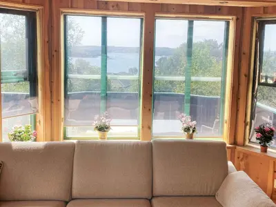 a couch sitting in a room with three windows at 4 person holiday home in Kjerrgarden in Kjerrgarden