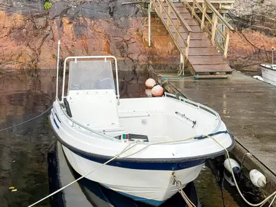a boat sitting in the water next to a dock at 4 person holiday home in Kjerrgarden in Kjerrgarden