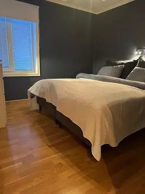 a bedroom with a large bed and a wooden floor at World championship, VM på ski Granåsen 2025 in Trondheim