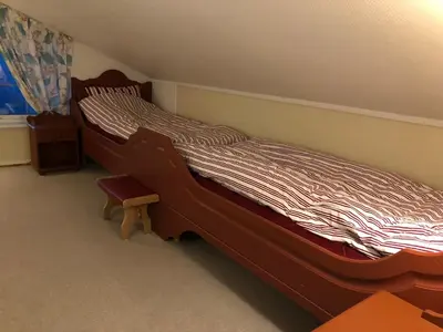 a bedroom with a bed with a wooden frame at Cabin with large outdoor area in Hamar