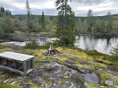 a bench on the rocks near a body of water at Turifoss Camping Cabin 2 in Svedjan