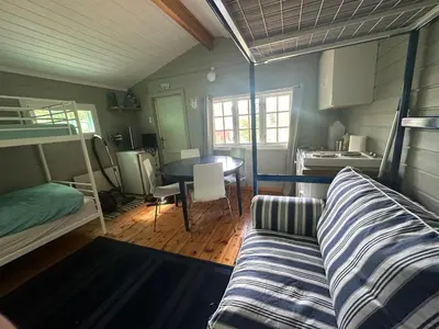 a bedroom with a bunk bed and a dining room at Turifoss Camping Cabin 2 in Svedjan