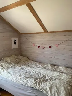 a bed in a room with hearts on the wall at SKI VM House 5 min walk to Granåsen ski stadion in Trondheim