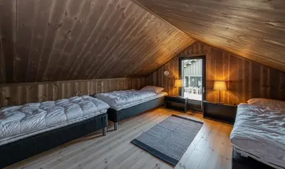a attic room with two beds and a window at Modern cabin Hafjell high standard ski-in out in Hafjell