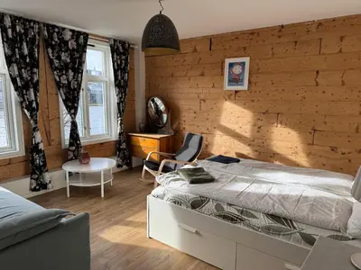 a bedroom with a bed and a wooden wall at Lake view apartment in center of Bergen - 3 bedrooms in Bergen