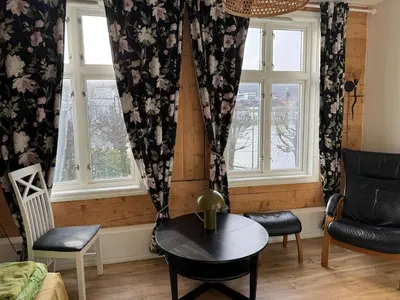 a living room with a table and two windows at Lake view apartment in center of Bergen - 3 bedrooms in Bergen
