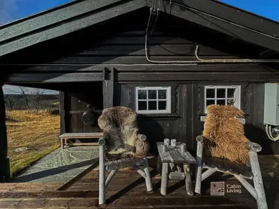 a shed with a couple of animals sitting on a bench at Cozy cabin near Geilo & Dagali terrace, grill, fireplace, view & WiFi in Hol