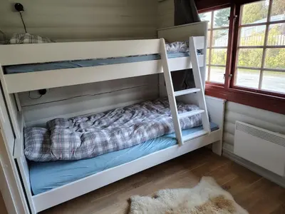 a bunk bed with a ladder in a room at Cozy apartment with pool in Bjorli