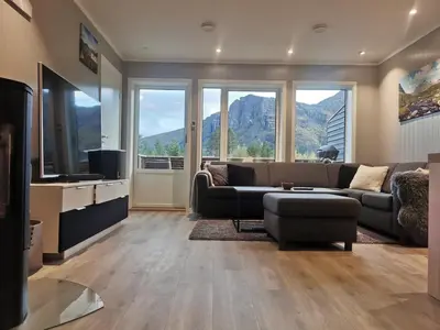 a living room with a couch and a tv at Lovely apartment with stunning views in Torset