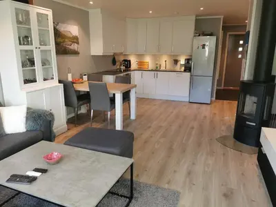 a living room with a table and a kitchen at Lovely apartment with stunning views in Torset