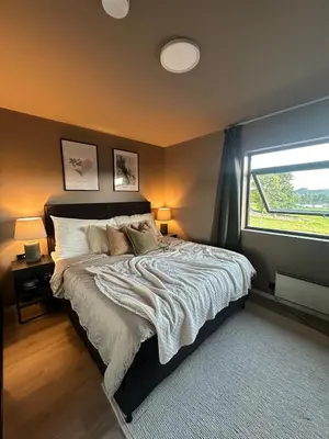 a bedroom with a large bed with a window at Delicate and new apartment in quiet surroundings in Trondheim