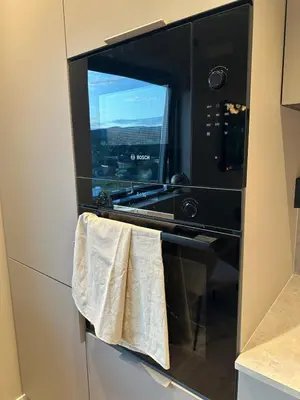 a microwave oven with a towel hanging from it at Delicate and new apartment in quiet surroundings in Trondheim