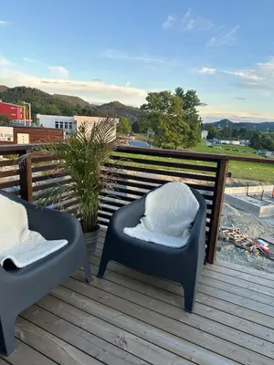 a pair of chairs sitting on a wooden deck at Delicate and new apartment in quiet surroundings in Trondheim