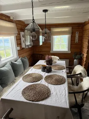 a dining room table with four plates on it at Chalet Skogshorn in Markegardlian