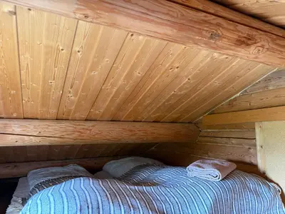 a bed in a cabin with a wooden ceiling at Chalet Skogshorn in Markegardlian