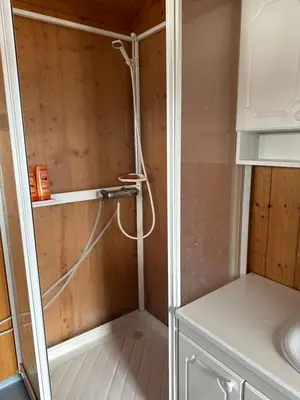 a shower with a hose hanging from a wall at Chalet Skogshorn in Markegardlian