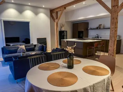 a kitchen and a living room with a table and a couch at MARINA LUXE - Two Bedrooms, High-End, Iconic Location & Private Parking in Ålesund