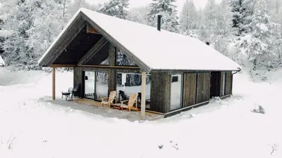 a cabin covered in snow in the woods at Modern Mountain Cabin - 3 Bedrooms - Sleeps 7 in Torpo