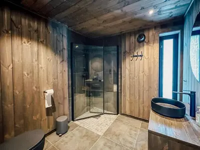 a bathroom with a glass shower and a sink at Modern Mountain Cabin - 3 Bedrooms - Sleeps 7 in Torpo