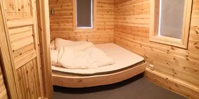 a small room with a bed in a wooden cabin at Cozy cabin centrally located in Hovden in Hovden