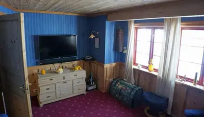 a living room with a television and a tvicterictericterswersswersswersswers at Cozy cabin centrally located in Hovden in Hovden