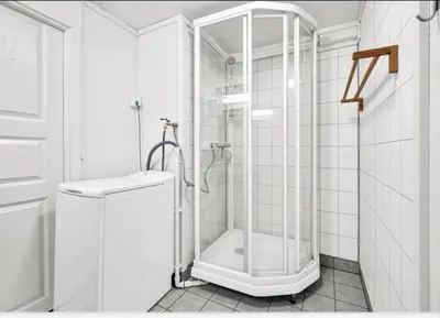 a white bathroom with a shower and a toilet at Granåsen World Championship Stay Walk to Ski Arena in Trondheim