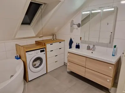 a bathroom with a washing machine and a sink at Granåsen World Championship Stay Walk to Ski Arena in Trondheim